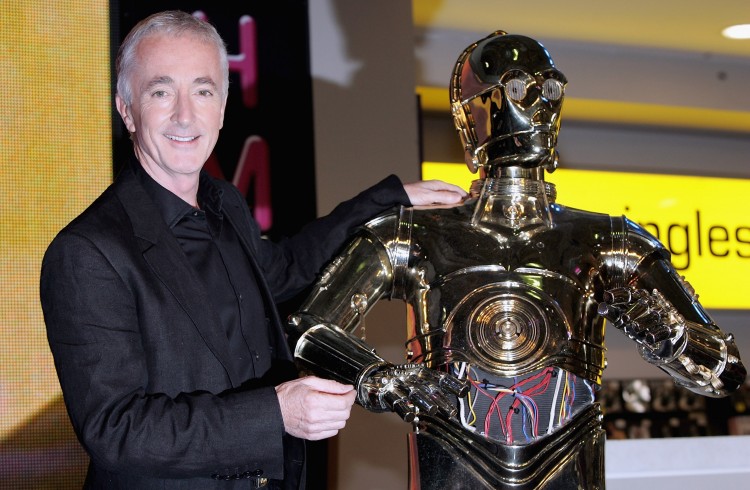 Herec z Hvězdných válek Anthony Daniels pózuje s modelem androida C-3PO, kterého ve sci-fi sérii ztvárnil. Na snímku při podepisování DVD z kolekce Star Wars: Epizoda III – Pomsta Sithů v roce 2005. (Gareth Cattermole/Getty Images)