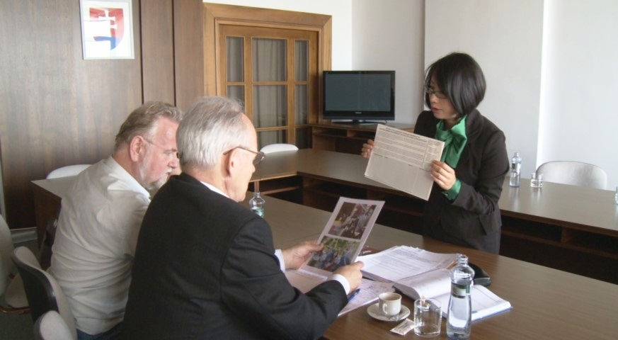 Pani Lisa Čang prezentuje poslancom Jozefovi Mikloškovi (napravo) a Petrovi Osuskému (naľavo) informácie o prenasledovaní svojej matky. (Zdroj: NTDTV)