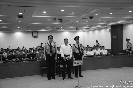 Po Si-laj stojí mezi dvěma důstojníky u soudu v čínském Ťi-nanu, hlavním městě provincie Šan-tung, v sobotu 21. září 2013. Byl odsouzen k doživotnímu vězení. (Weibo.com )