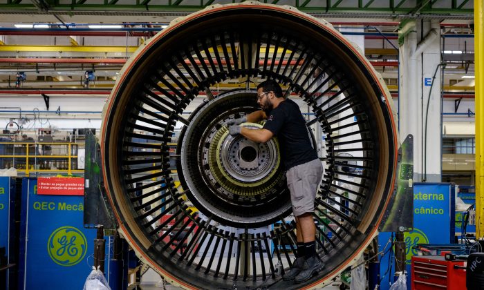 Muž pracuje s tryskovým motorem v letecké společnosti General Electric's, Rio de Janeiro, ilustr. foto. (YASUYOSHI CHIBA / AFP / Getty Images)
