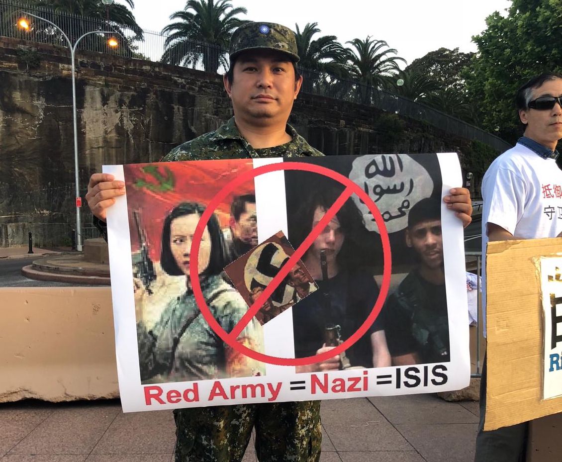Protestní transparent vyjadřujcí názor, že Rudé gardy oslavované v opeře „Lake Honghu“ (Jezero Chung-chu) se dopouštěli masového vyvražďování obyvatelstva, podobně jako nacisté za II. světové války bevo ISIS v současnosti. Protestující stojí před Opera House v Sydney, 4. listopadu 2018. (Poskytnuto aktivisty)