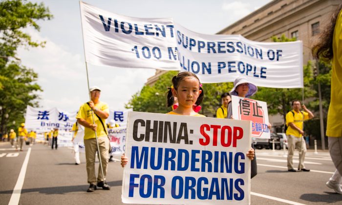 Mladá stoupenkyně Falun Dafa drží ceduli vyzývající Čínu k zastavení zabíjení vězňů svědomí pro jejich orgány. Protestní akce ve Washingtonu, 20. července 2017. (Benjamin Chasteen / The Epoch Times)